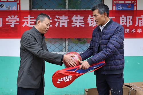 3.郑州市信息技术学校副校长张继波为二郎庙小学赠送体育器材