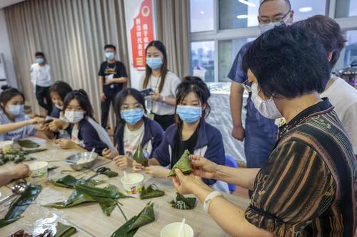 8校长韦艳春和同学们一起包粽子