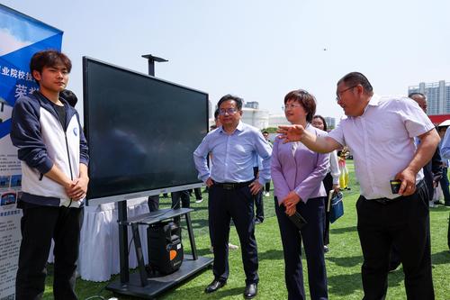 3校党委书记邵元辉向郑州市教育局党组书记、局长王丽娟汇报学校展位展示情况